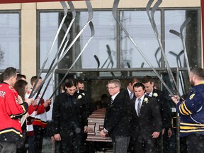 NHL player Steve Montador is saluted as his casket is carried out of his Mississauga, Ont. funeral in February 2015. (Veronica Henri/Postmedia Network)