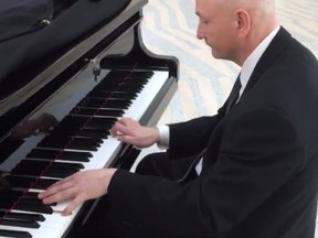 Edmonton City Councillor Mike Nickel playing the piano in City Hall. Screen grab from video shot by another City Councillor Andrew Knack.