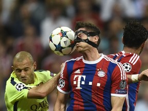 Bayern Munich forward Robert Lewandowski fights for the ball with Barcelona defender Javier Mascherano (left) during their Champions League semifinal in Munich on May 12, 2015. (AFP PHOTO/ODD ANDERSEN)