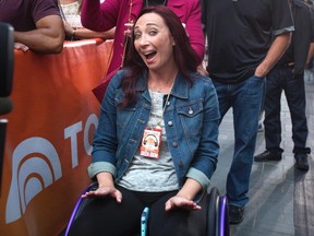 Former U.S. Olympic swimmer Amy Van Dyken-Rouen poses for a photo as she sits in her wheelchair and listens to Usher perform on NBC's "Today Show" in Manhattan on Sept. 5, 2014. (Carlo Allegri/Reuters/Files)