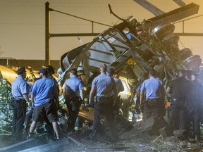 Rescue workers search for victims in the wreckage of a derailed Amtrak train in Philadelphia, Pennsylvania May 12, 2015. REUTERS/Bryan Woolston