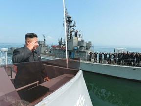 North Korean leader Kim Jong Un (L) salutes during a landing drill of the Army Ground, Naval, Air and Anti-Air forces of the Korean People's Army (KPA) in this undated photo released by North Korea's Korean Central News Agency (KCNA) in Pyongyang July 5, 2014.  REUTERS/KCNA