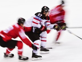 Forward Sidney Crosby (C) of Canada controls the puck during the group A preliminary round match Switzerland vs Canada at the 2015 IIHF Ice Hockey World Championships on May 10, 2015 at the O2 Arena in Prague. Canada won the match 7-2. AFP PHOTO / JONATHAN NACKSTRAND