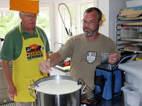 BRUCE BELL/THE INTELLIGENCER
Cheese maker Glenn Symons of Lighthall Vineyards adds ingrediants to a batch sheep's milk Brie while Great Canadian Cheese Festival dierctor George Kolesnikovs keeps a watchful eye. Symons made the cheese during a media even for the Festival at the Mystic Dandelion B&B in Bloomfield on Tuesday afternoon.