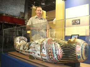 Gordon Robinson, curator of the Pump House Steam Museum, stands next to a replica of an ancient Egyptian sarcophagus, part of a new display on Egypt at the museum. (Michael Lea/The Whig-Standard)