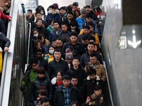 People ride on escalator and walk on a stair as they head to a platform during a rush hour at a subway station in Beijing, February 25, 2015. REUTERS/Kim Kyung-Hoon, file