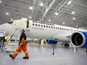 A Bombardier worker walks past the CS300 Aircraft in the hangar prior to its' test flight in Mirabel, Que., February 27, 2015. (REUTERS/Christinne Muschi)