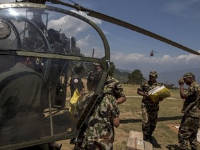 Nepal Military personnel load relief supplies onto an Nepalese helicopter at Charikot Village, in Dolakha, Nepal, May 14, 2015. REUTERS/Athit Perawongmetha