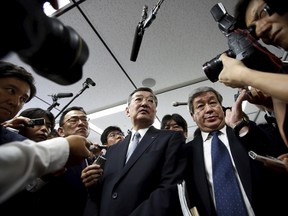 Sharp Corp's chief executive Kozo Takahashi (C) is surrounded by reporters and photographers after a news conference in Tokyo May 14, 2015. REUTERS/Issei Kato