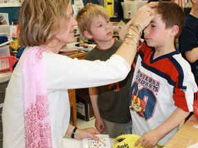 Rosedale Public School teacher Nancy Mulholland places a bindi on the forehead of one of her students. Mulholland organized an India Celebration Day following her own four-week journey to the country.
CARL HNATYSHYN/SARNIA THIS WEEK