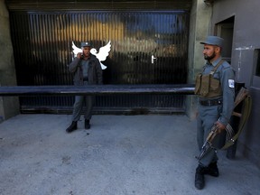 Afghan police guard the gate of a guest house after an attack in Kabul May 14, 2015. At least one gunman attacked the guest house popular with foreigners in Kabul on Wednesday killing at least five people, including an American and two Indians, in a bold assault that showed Afghanistan still faces security challenges. REUTERS/Omar Sobhani