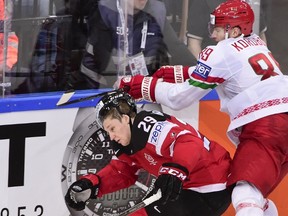 Forward Nathan MacKinnon (left) of Canada gets hit by Dmitri Korobov of Belarus during the world championship quarterfinal May 14, 2015 at the O2 Arena in Prague. (AFP PHOTO/JONATHAN NACKSTRAND)
