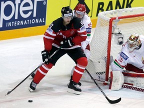 Jason Spezza challenges Oleg Yevenko and goaltender Kevin Lalande of Belarus during Thursday's quarterfinal game at the O2 arena in Prague. (David W Cerny, Reuters)