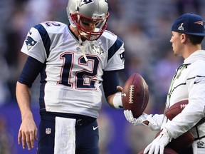 Patriots quarterback Tom Brady takes a football from a ball boy as he warms up before Super Bowl XLIX against the Seahawks in Glendale, Ariz., on Sunday, Feb. 1, 2015. (Kyle Terada/USA TODAY Sports/Files)