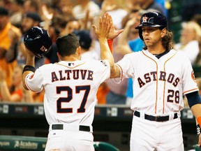 Astros’ Colby Rasmus greets teammate Jose Altuve after Altuve scores in the first inning on Thursday night against the Blue Jays at Minute Maid Park in Houston. (AFP/PHOTO)