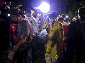 Miners and rescuers carry the corpse of one of the fifteen miners who were trapped by the collapse of a gold mine, near the area of El Saibo, in Riosucio, Caldas department, Colombia, on May 14, 2015. At least 15 people were trapped underground Wednesday when an unlicensed gold mine in western Colombia collapsed, authorities said, as rescue workers raced to reach them. AFP PHOTO / LUIS ROBAYO