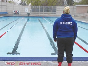 Jadeen Howe, one of the lifeguards returning to monitor the Vulcan pool this season, looks over an empty pool on the day of its official opening. Howe said that there were a couple lane swimmers who braved the unfavourable weather this morning, but attendance has been very low otherwise.