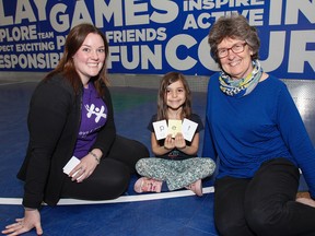 Colleen Brick, manager of education programs at the Boys the Girls Club of Kingston, left, Lexi Katsoulas a five-year-old club member and Jan MacLean from The Reading Clinic use reading cards to help Katsoulas with her reading skills at the clubs west end facility in Kingston, Ont. on Tuesday May 12, 2015. Julia McKay/The Kingston Whig-Standard/Postmedia Network