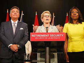 Ontario Premier Kathleen Wynne (centre) with Finance Minister Charles Sousa and Mitzi Hunter, then associate finance minister in charge of the ORPP, speak to media at Queen's Park on June 26, 2014. (Michael Peake/Toronto Sun)