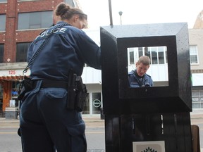 Police look in a garbage can near the scene of a fatal stabbing on Richmond St. between King and Dundas streets (Free Press file photo)