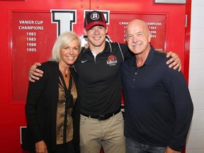 University of Calgary Dinos Jake Harty (centre) is hugged by mom Kim and dad Dave after he was picked by the Ottawa RedBlacks in the second round of the CFL draft on Tuesday, May 12, 2015. (Jim Wells/Postmedia Network)