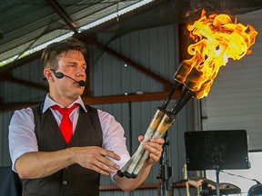 Kobbler Jay, the Eccentric Juggler, holds up a set  of torches as he prepares for his final act, juggling torches while walking barefoot on broken glass, during a performance at Riveferfest in Frankford on Saturday May 16, 2015.  Tim Miller/The Intelligencer