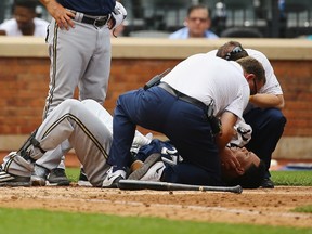 Carlos Gomez #27 of the Milwaukee Brewers is tended to after he is hit by a pitch by Noah Syndergaard #34 of the New York Mets in the sixth inning during their game at Citi Field on May 17, 2015 in New York City. (Al Bello/Getty Images/AFP)