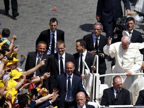 Pope Francis' cap is blown off as he greets the faithful at the end of the ceremony for the canonization of four nuns at Saint Peter's square in the Vatican City, May 17, 2015. (TONY GENTILE/Reuters)