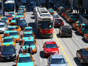 Over 100 Cabs take over the streets around City Hall to protest of Uber as they urge the city to put the ride sharing service out of business in Toronto on Thursday May 14, 2015. Dave Abel/Toronto Sun/Postmedia Network