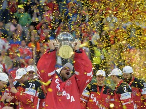 Canada's goalkeeper Mike Smith raises the trophy of the IIHF Ice Hockey World Championship during the medal ceremony after the IIHF Ice Hockey World Championship final match Canada vs Russia on May 17, 2015 at the O2 Arena in Prague. (AFP PHOTO / MICHAL CIZEK)