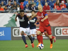 Toronto FC midfielder Michael Bradley tries to drive by New England Revolution forward Juan Agudelo on May 17. (USA Today Sports)
