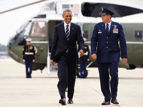 U.S. President Barack Obama laughs as he walks with U.S. Air Force Colonel John Millard, commander of the 89th Airlift Wing, as he arrives to board Air Force One at Joint Base Andrews, Md., May 18, 2015. (JONATHAN ERNST/Reuters)
