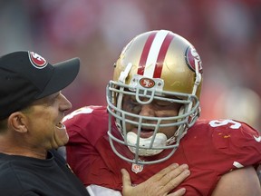 Head coach Jim Harbaugh of the San Francisco 49ers celebrates with Justin Smith #94 after a forced fumble in the fourth quarter against the Washington Redskins at Levi's Stadium on November 23, 2014 in Santa Clara, California. (Thearon W. Henderson/Getty Images/AFP)