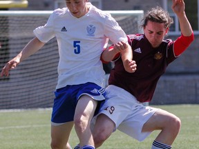 Kingston Blues’ Isaac MacFadyen, left, battles with Regiopolis-Notre Dame Panthers’ Bryant Bishop for the ball during the first half of a Kingston Area Secondary Schools Athletic Association senior boys soccer semifinal game at Tindall Field on Tuesday. (Julia McKay/The Whig-Standard)