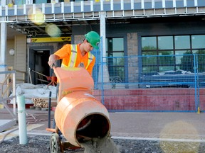 Justin Gagnon, of the firm Huyer Enterprises, drains water and concrete from a mixer as workers continue on the ground floor of the Aquatarium in Brockville on Tuesday. (RONALD ZAJAC/The Recorder and Times)