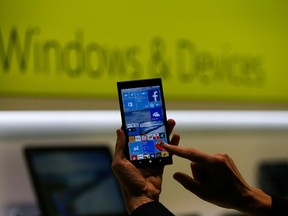 A Microsoft representative shows a smartphone with Windows 10 operating system at the CeBIT trade fair in Hanover in this file photo from March 15, 2015. REUTERS/Morris Mac Matzen/Files