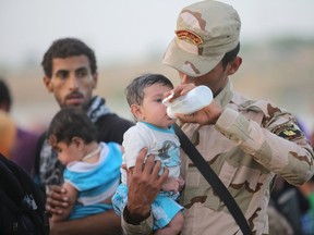 An Iraqi soldier carries a displaced kid from Ramadi at the outskirts of Baghdad, May 19, 2015. Iraqi security forces on Tuesday deployed tanks and artillery around Ramadi to confront Islamic State fighters who have captured the city in a major defeat for the Baghdad government and its Western backers. REUTERS/Stringer