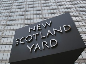 The rotating triangular sign is seen outside New Scotland Yard in central London. REUTERS/Stefan Wermuth (BRITAIN  - Tags: CRIME LAW POLITICS)