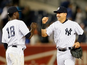 Didi Gregorius (18) and Jacoby Ellsbury of the New York Yankees celebrate their win over the Baltimore Orioles on May 8, 2015 at Yankee Stadium. (Elsa/Getty Images/AFP)