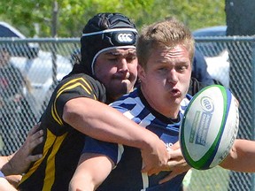 THS defender Ty Shemko grabs QSS ballhandler Devin Rose during the Bay of Quinte senior boys rugby final Wednesday at MAS Park. (Catherine Frost for The Intelligencer)