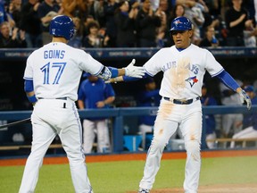 Blue Jays baserunner Ezequiel Carrera (right) is congratulated by teammate Ryan Goins after scoring a run in the fourth inning against the Angels during MLB action in Toronto on Wednesday, May 20, 2015. (Stan Behal/Postmedia Network)