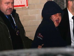 New York City police officers escort 31-Year-old Erika Menendez to an awaiting car as she screams, at New York City  Police department 112th Precinct in the Queens Borough of New York, December 29, 2012.   REUTERS/Joshua Lott, file