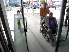 ERNST KUGLIN/THE INTELLIGENCER
Volunteer Bill Vandervoort helps Quinte West Mayor Jim Harrison negotiate opening the main entrance of city hall in Trenton. Quinte Access and the city's accessibility advisory committee will host the annual Access-A-Thon May 30 at the Front Street parking lot in Trenton. The event runs from 9 a.m. to 11 a.m.