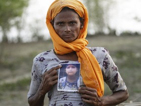 Rohiakar, a Rohingya Muslim woman, shows a picture of her daughter Saywar Nuyar, 22, who is being held by a human trafficker, at a refugee camp outside Sittwe, Myanmar May 21, 2015. (REUTERS/Soe Zeya Tun)