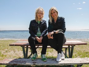 Local music duo Kris + Dee — Kris Abbott, left, and Dee McNeil — sit on a picnic table close to the shoreline at Crerar Beach in Kingston. The beach and sounds of the waves helped to inspire their newest album, A Great Long Game. (Julia McKay/The Whig-Standard)