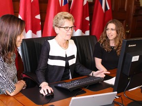 Premier Kathleen Wynne sits down with Haley Overland, right, of Today’s Parent, and Lindsay Lynch, left, of Twitter Canada, on May 21, 2015 for a Twitter chat in recognition of Sexual Assault Awareness Month and #project97. ​(Toronto Sun/Antonella Artuso)