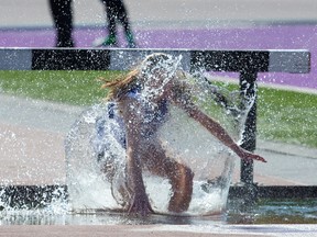 Margot Linker, of Oakridge, slips in the water pit during a steeplechase heat at the WOSSAA track and field championships at TD Stadium on Thursday. (MIKE HENSEN, The London Free Press)