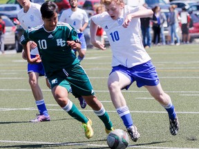 Holy Cross Crusaders' Santiago Rivera moves to intercept the ball from Kingston Blues' Henry Standage during the second half of the Kingston Area Secondary Schools Athletic Association senior boys soccer championship game at Miklas-McCarney Field on Thursday May 21. (Julia McKay/The Whig-Standard)