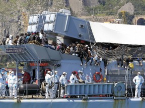 Migrants stand on board Italian Navy ship Chimera before disembarking in the southern harbour of Salerno April 22, 2015. The European Union must take a collective stand to tackle migrant trafficking at its source in African countries, Italy's Prime Minister Matteo Renzi said on Wednesday ahead of an emergency summit of the bloc's leaders to discuss the crisis. Renzi spoke as Italian navy and coast guard vessels were taking more than 1,200 migrants rescued in other operations since Monday to ports across southern Italy. One ship carrying 545 migrants, including 174 women and children, was heading to Salerno, on the mainland south of Naples, to ease the strain on overcrowded centres receiving migrants in ports in Sicily.   REUTERS/Ciro De Luca