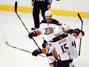 Ducks defenceman Simon Despres (24) celebrates with teammates Ryan Getzlaf (15) and Cam Fowler (4) after scoring the eventual game-winning goal against the Blackhawks during second period action in Game 3 of the Western Conference final in Chicago on Thursday, May 21, 2015. (Jerry Lai/USA TODAY Sports)